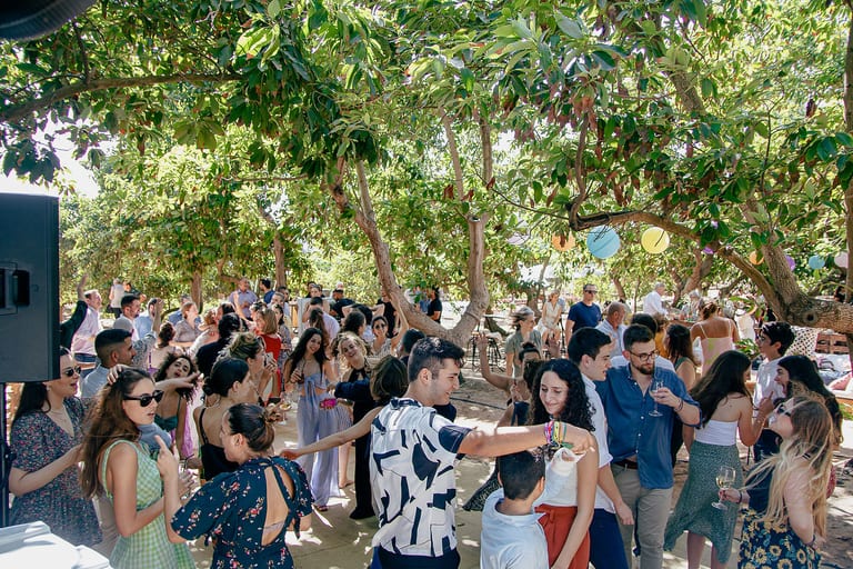 אורחים רוקדים ביחד בין העצים