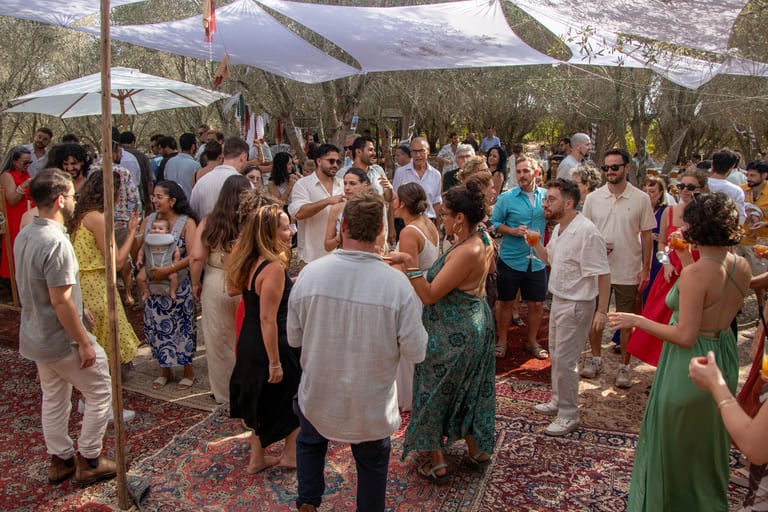 אורחים רוקדים על שטיחים מתחת לשמשיות