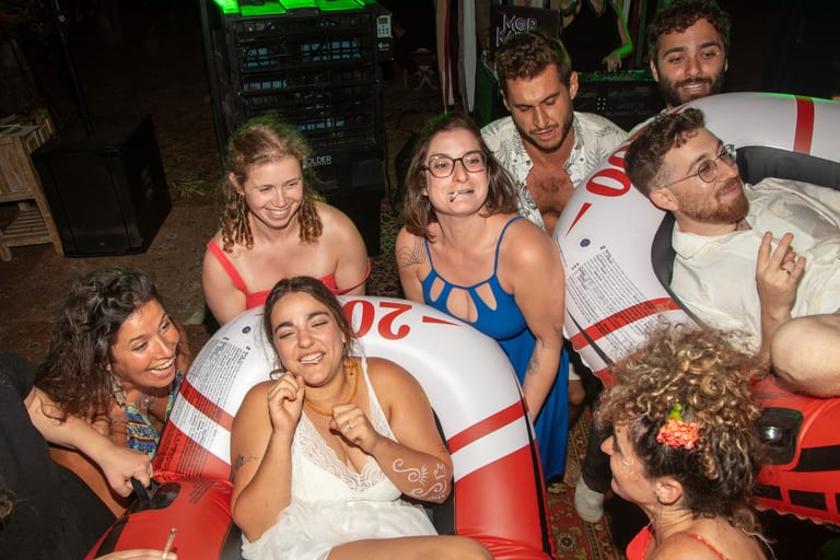 אורחים צוחקים יושבים בתוך גלגל ים מתנפח