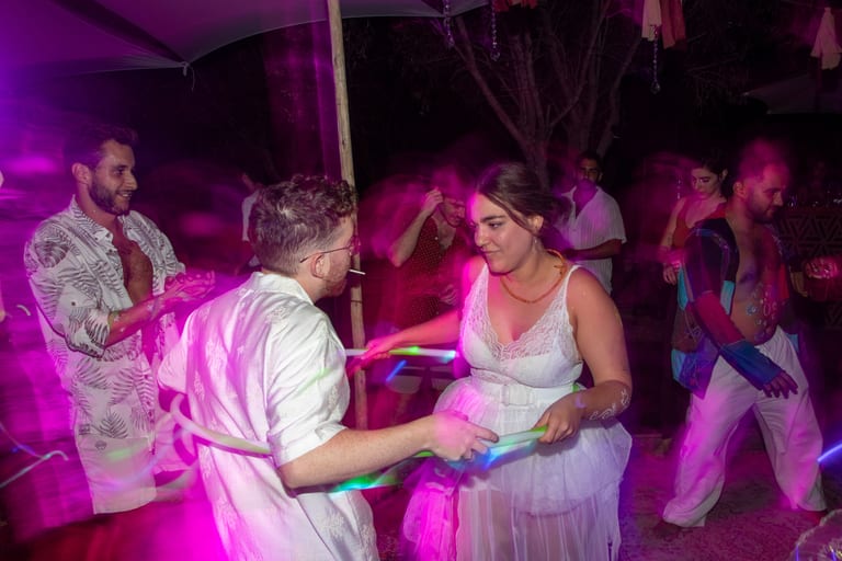 הכלה והחתן רוקדים באור סגול וורוד